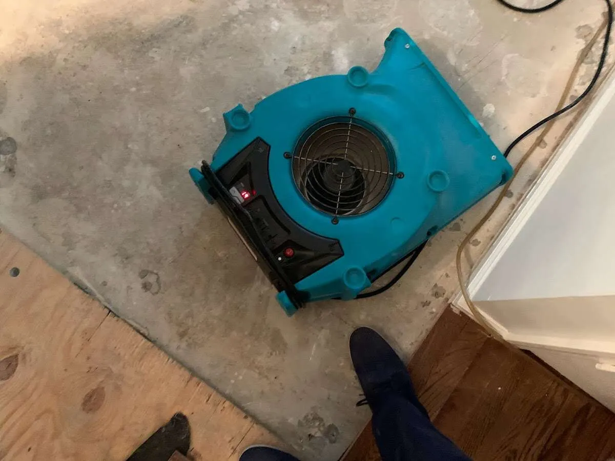 Air mover drying subfloor during Commercial Water Damage Restoration in Church Hill